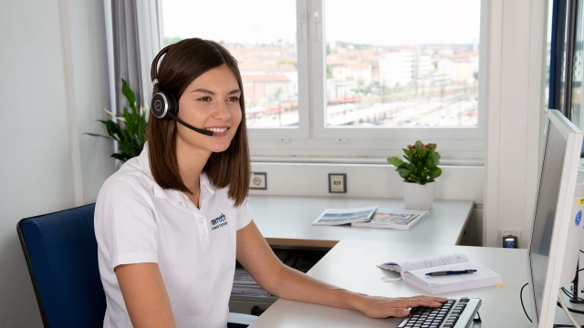 An employee of the Bosch Rexroth Academy talking to a customer on the phone.