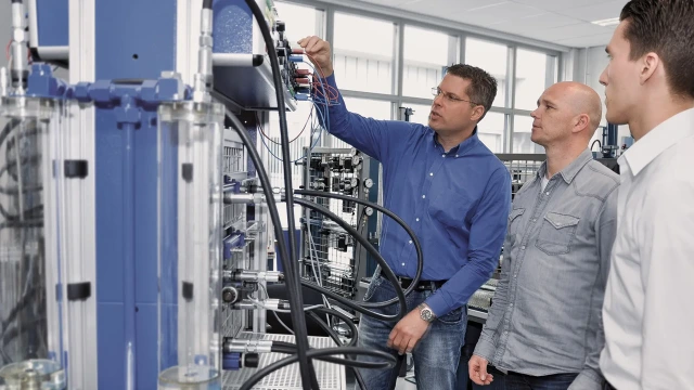 The trainer demonstrates the behavior of the hydraulic exercise setup to the participants. Link to the Industrial Hydraulics training program.