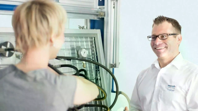 A Rexroth trainer explains the exercise setup using a set of equipment on the hydraulic training system. 