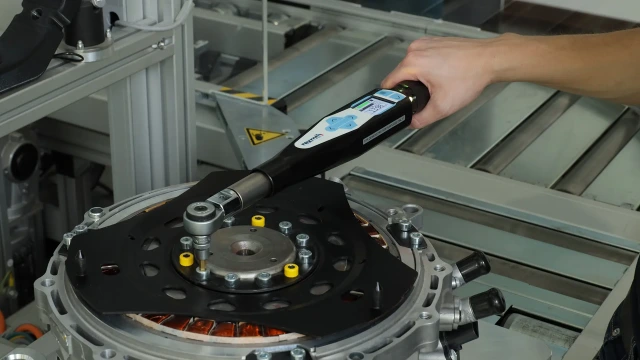 An assembly worker uses a Bosch Rexroth angle screwdriver to fasten a panel at the assembly workstation. Link to the Tightening Technology training course