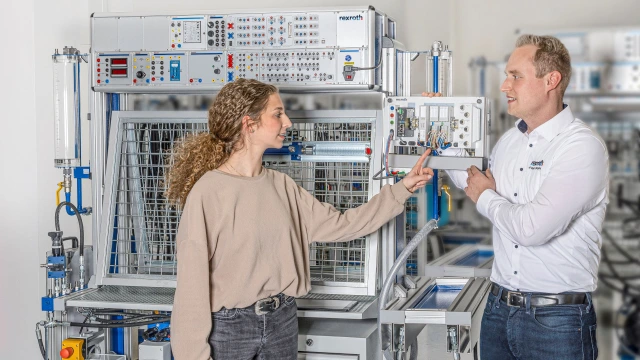 Trainer and training participants in front of the Hydraulix 300 hydraulic training system. 